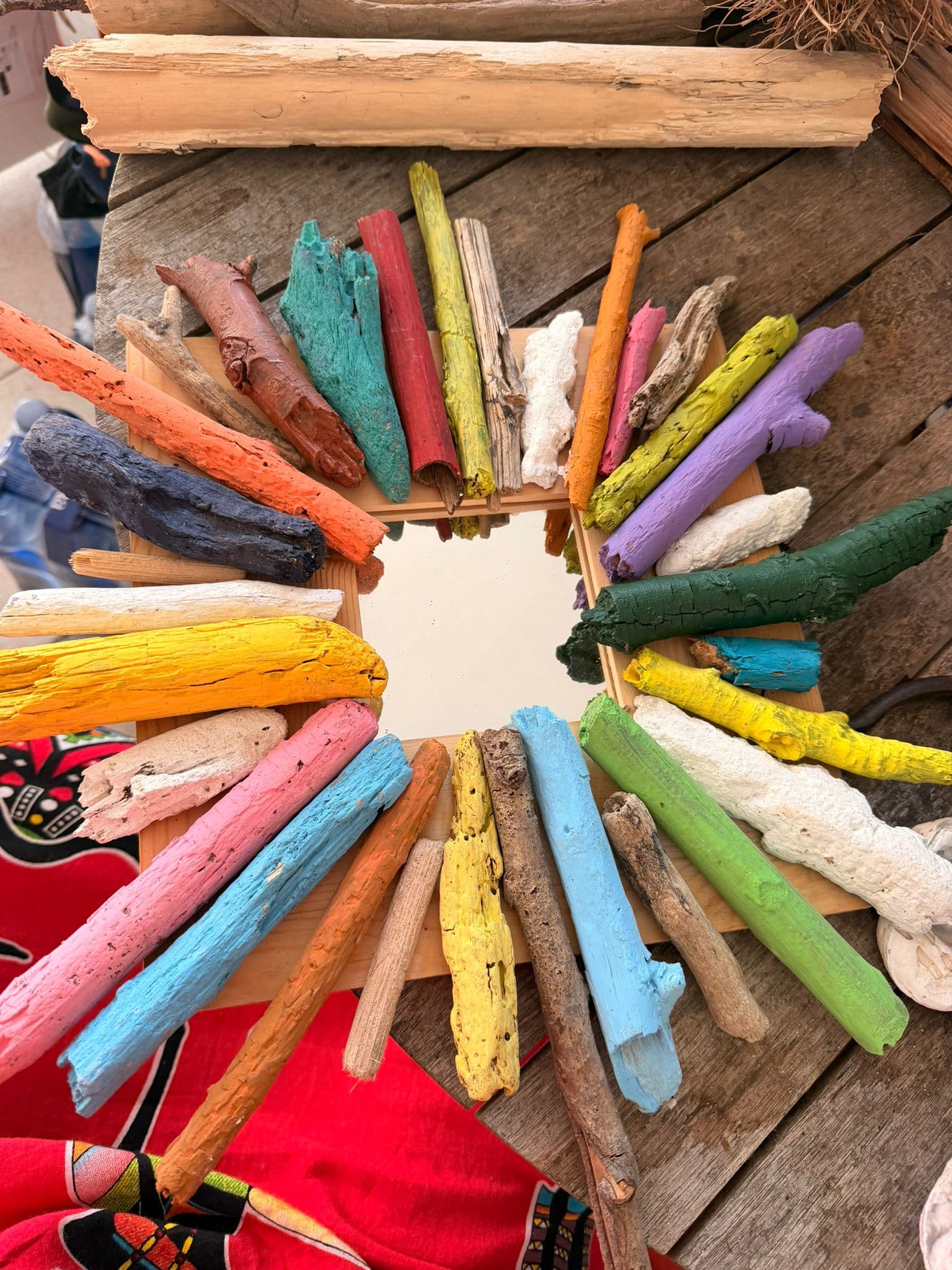 Espelho quadrado com raios de madeira pintada em cores vivas